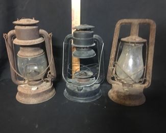 Lanterns. These three kerosene lanterns will make great “rustic decor" pieces. The two on the outside do not have font caps. The one in the center has no globe. The one on the right has no bail.