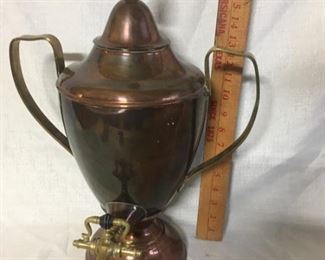 Copper and brass urn with brass topped wooden finial and wooden trim on spigot.