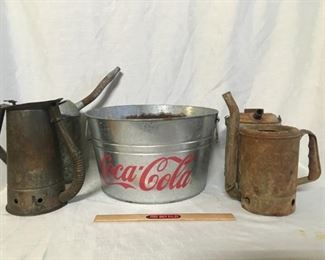 Galvanized containers. The Coca-Cola tub has holes in the bottom to lit water drain out. Theee have spouts to deliver oil or water to engines.