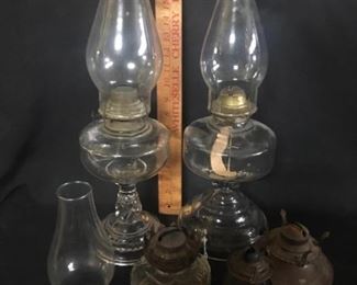 Kerosene lamps. Five table lamps. One of the tall ones has damage.
