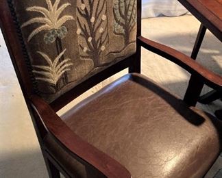 Each of the arm chairs has a nail-head trimmed upholstered back and leather seat.