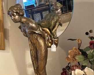 Tall statue with round mirror