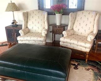 Matching pair of wing back chairs, leather storage ottoman