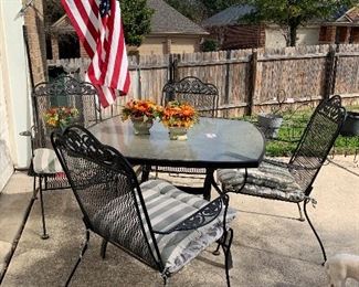 Very nice glass top iron table and four chairs 