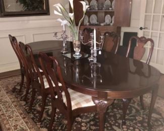 Davis cabinet co. Mahogany queen Ann dining table with six side chairs and two arm chairs with plaid seats.  Colonial House corner cabinet, brown and green area rug. 