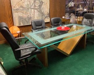 Lot 5001.  $750.00  Glass Conference Table. w/oak "M" Base and Chrome Accents. So much Potential. 84"L x 42"W x 29.5"H w/ 3/4" thick glass. Very sturdy and glass in etched around the edge of the glass. Chairs are sold separately in next lot. Chairs are sold separately in next lot.