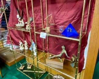 Lot 5007.  $750.00  2 Vintage Brass Etagere 4 Tier display units. Hello amazing plant stand or bones of a cool zoom background!  The metal frame has a bamboo motif, the glass pieces are smoked, all in pretty good shape too. This would be an easy refinish project. I am imagining spray painting in a matte black or matte gold.  The contents of the shelves will be for sale in later lots.	27"W  x  14" D  x  68"H