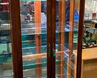 Lot 5013.  $475.00  Beautiful Howard Miller branded Cherry wood and glass display case w/ light and key.  Howard Miller sign could potentially be removed. Features  5 glass shelves and light that makes this a great piece for home, Office or Store.  32 1/2" W x 14 1/2" D x 76" H
