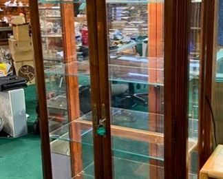 Lot 5013.  $475.00  Beautiful Howard Miller branded Cherry wood and glass display case w/ light and key.  Howard Miller sign could potentially be removed. Features  5 glass shelves and light that makes this a great piece for home, Office or Store.  32 1/2" W x 14 1/2" D x 76" H
