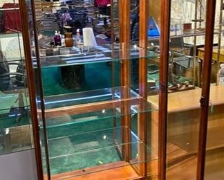 Lot 5013.  $475.00  Beautiful Howard Miller branded Cherry wood and glass display case w/ light and key.  Howard Miller sign could potentially be removed. Features  5 glass shelves and light that makes this a great piece for home, Office or Store.  32 1/2" W x 14 1/2" D x 76" H