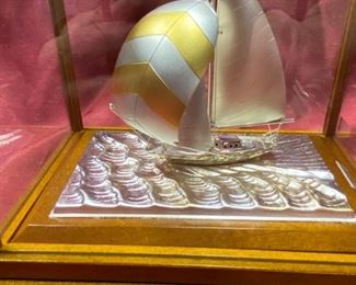 Lot 5026. $60.00 Silver-plated sailboat by Takehiko in Wood and glass case.  6" H  x 6.8  L x  4" W.  Very Good condition overall