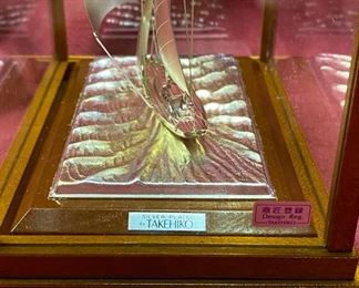 Lot 5026. $60.00 Silver-plated sailboat by Takehiko in Wood and glass case.  6" H  x 6.8  L x  4" W.  Very Good condition overall