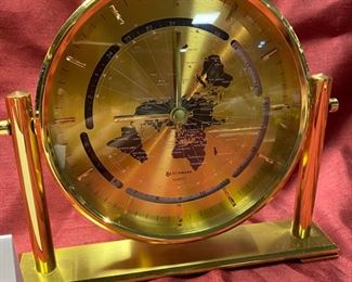 Lot 5062.  $32.00. Benchmark Quartz World Clock in Brass toned metal . 5.5"diameter Face, 7.75" W  x 1.5" D stand. Battery-Operated. Quantity Avail. 3.
