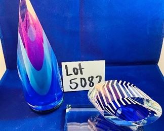 Lot 5082.  $275.00    2 Gorgeous Pieces of Harrie Glass, the first is a  STUNNING Flame in blues, purple, and clear 9.5" H  x 3" W.  The second piece is a blue and clear Ellipse on base 6" Wx 3.25" D. I was able to find these same flame online fetching $400 and an ellipse without the base for $165. So our price is a STEAL for both pieces.