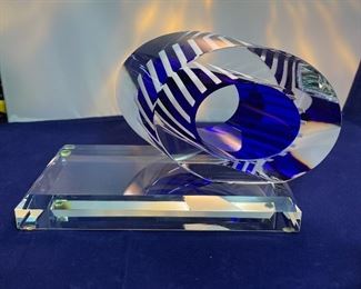 Lot 5082.  $275.00    2 Gorgeous Pieces of Harrie Glass, the first is a  STUNNING Flame in blues, purple, and clear 9.5" H  x 3" W.  The second piece is a blue and clear Ellipse on base 6" W x 3.25" D. I was able to find these same flame pieces online fetching $400 and an ellipse without the base for $165. So our price is a STEAL for both pieces.  