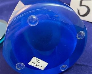 Lot 5082.  $275.00    2 Gorgeous Pieces of Harrie Glass, the first is a  STUNNING Flame in blues, purple, and clear 9.5" H  x 3" W.  The second piece is a blue and clear Ellipse on base 6" W x 3.25" D. I was able to find these same flame online fetching $400 and an ellipse without the base for $165. So our price is a STEAL for both pieces.