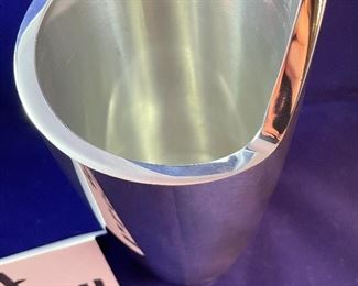 Lot 5094.   $65.00. Nambe Spiral Wine Chiller 8.5" t, Designer Smith Celentano. "The Spiral Wine Chiller" offers the perfect cradling shape for a bottle of your favorite vintage. The simple, yet bold, artistic statement of the design resembles the winding turn of a spiral staircase, sure to stand out in your décor. Chill it in the freezer beforehand to keep your whites and dessert wines cool" Box states Sug. Retail $135. Current Retail on Nambe site $150.00, includes box. We have 12 wine chillers.