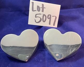 Lot 5097.   $30.00  A Pair of Nambé #6194 Heart Paperweights. 1994 (one shows signs of wear, one is in excellent shape)	4"x2"w
