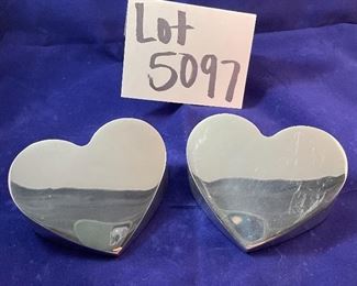 Lot 5097.   $30.00  A Pair of Nambé #6194 Heart Paperweights. 1994 (one shows signs of wear, one is in excellent shape)	4"x2"w