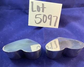 Lot 5097.   $30.00  A Pair of Nambé #6194 Heart Paperweights. 1994 (one shows signs of wear, one is in excellent shape)	4"x2"w