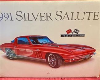 Lot 5121. $25.00. 1991 Hugo Prado Silver Salute Poster of a 1966 Corvette "427" Turbo-Jet (in plastic, but there seems to be a little water damage in the upper left corner, once framed and matted this wouldn't be noticeable) and a commemorative plate of a 1956 & 1957 Corvette from World Wide Line (Style: 694) its a sample. Plate Stand Not included.  25" W  x 19" H print. Plate: 10" Diameter 