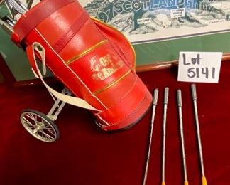 Lot 5141. $75.00. History of Golf Framed Art. Hand Signed C. Burton 1988. Signed and Numbered,  #944/1000. AND Novelty MINIATURE Golf clubs and Cart w/steel shafts Including 4 woods, Irons, Sand wedge and putter and a bag on wheels. Balls too.  Scotch Whisky or Old Andrews label on the bag.  Nice addition to your man cave!