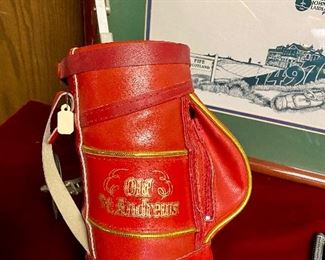 Lot 5141. $75.00. History of Golf Framed Art. Hand Signed C. Burton 1988. Signed and Numbered,  #944/1000. AND Novelty MINIATURE Golf clubs and Cart w/steel shafts Including 4 woods, Irons, Sand wedge and putter and a bag on wheels. Balls too.  Scotch Whisky or Old Andrews label on the bag.  Nice addition to your man cave!