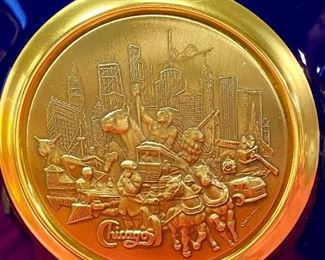 Lot 5145. $80.00. Very Cool Chicago Lot. T. Chamness Landmark Ink Art (18.5" H  x 14.25" W  has a plexiglass front, probably needs a piece of glass in there). A Wooden Medallion of Chicago Landmarks by Kurt Mager (6.25" diameter ).  A City of Chicago Crest clock with a hinge to reveal a clock (3"). The Medallion Plate by Pickard w/metal art by Kurt Mager (same art as the wooden medallion. 