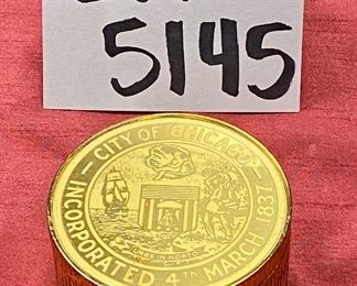 Lot 5145. $80.00. Very Cool Chicago Lot. T. Chamness Landmark Ink Art (18.5" H  x 14.25" W  has a plexiglass front, probably needs a piece of glass in there). A Wooden Medallion of Chicago Landmarks by Kurt Mager (6.25" diameter ).  A City of Chicago Crest clock with a hinge to reveal a clock (3"). The Medallion Plate by Pickard w/metal art by Kurt Mager (same art as the wooden medallion. 