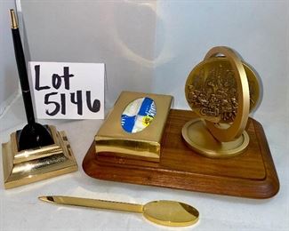 Lot 5146. $48.00  Desk Accessories; Gold Tone letter opener, gold tone Kleenex holder,  Chicago spinning medallion on a wood base, and a Cross ballpoint pen with brass stand. 