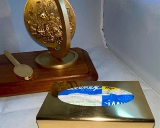 Lot 5146. $48.00  Desk Accessories; Gold Tone letter opener, gold tone Kleenex holder,  Chicago spinning medallion on a wood base, and a Cross ballpoint pen with brass stand. 