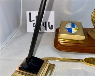 Lot 5146. $48.00  Desk Accessories; Gold Tone letter opener, gold tone Kleenex holder,  Chicago spinning medallion on a wood base, and a Cross ballpoint pen with brass stand. 