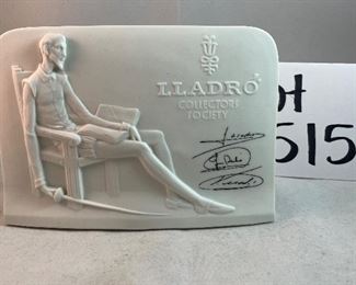 Lot 5157.  $115.00. A lovely Lladro lot includes a 1985- Lladro Collectors Society Don Quixote Plaque (6"wx4"h) with a shell design on the back. 1984 Lladro Cat 'n Mouse (2.5"hx3"w) figurine, and a Porcelain "Nosegay" 4.5" x 2"h. Little wooden stand not included. 