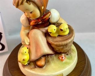 Lot 5158. $56.00. Interesting Lot of 5 Hummel and Goebel Figures. Hummel "Chick Girl" 3.5"h x 3"w. Hummel "Apple Tree Girl" 3.5"h x 2.5"w. Hummel Boy with Hen 3"h x 2"w. Goebel Bluebird, and Vintage Goebel Bunny Painting Egg 4-827 (1979-1991) 3.5"h x 3"w. Wooden stand not included. 