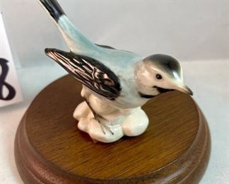 Lot 5158. $56.00. Interesting Lot of 5 Hummel and Goebel Figures. Hummel "Chick Girl" 3.5"h x 3"w. Hummel "Apple Tree Girl" 3.5"h x 2.5"w. Hummel Boy with Hen 3"h x 2"w. Goebel Bluebird, and Vintage Goebel Bunny Painting Egg 4-827 (1979-1991) 3.5"h x 3"w. Wooden stand not included. 