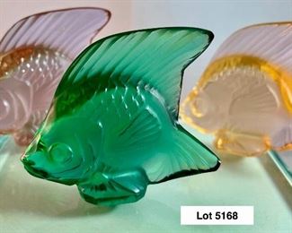 Lot 5168. $125.00. This lot includes 3 Lalique Paris Angel Fish. The fish are in Peach, Teal, and Pink w/3 small mirrored discs. Also included are 3 suede Lalique drawstring bags and only 2 Lalique boxes. The wooden stand isn't included. 