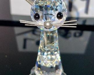 Lot 5179. $28.00. Swarovski Crystal Zoo Cat closely watching 2 birds on a birdbath (one of the birds was reattached to piece). Cat is 2.75"h x 1"w with a flexible tail.  Bird Bath: 2/5"h x 3"w. Both pieces are signed. Sold as-is.