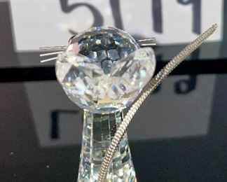 Lot 5179. $28.00. Swarovski Crystal Zoo Cat closely watching 2 birds on a birdbath (one of the birds was reattached to piece). Cat is 2.75"h x 1"w with a flexible tail.  Bird Bath: 2/5"h x 3"w. Both pieces are signed. Sold as-is.