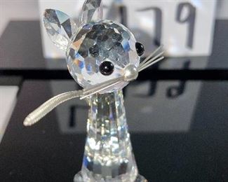 Lot 5179. $28.00. Swarovski Crystal Zoo Cat closely watching 2 birds on a birdbath (one of the birds was reattached to piece). Cat is 2.75"h x 1"w with a flexible tail.  Bird Bath: 2/5"h x 3"w. Both pieces are signed. Sold as-is.