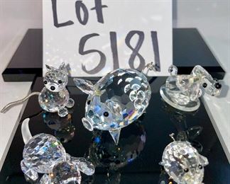 Lot 5181. $90.00. Piggies, puppies, and a kitty. Mama Pig (1.5"w x 2"lx1"h) and piglet (1") from Swarovski Crystal Zoo (look at their cute tails). 2 pups one on an oval base and one lounging. The lounger is signed by Swarovski. The kitty is signed by Crystal Zoo and 1.5"h x .75"w. 