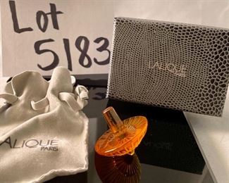 Lot 5183. $70.00ea.  Oh la la! An Amber Lalique "Toupie" Spinning Top, it is signed on the stem. We have 3 of the Amber colored tops, each includes a branded box and string suede bag. 1.25"h x 1.5"w.