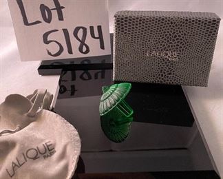 Lot 5184. $70.00.  Oh la la! An Emerald Lalique "Toupie" Spinning Top, it is signed on the stem. We have 1 of the Emerald colored top, includes a branded box and string suede bag. 1.25"h x 1.5"w.