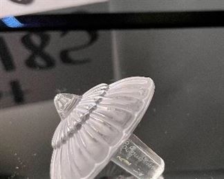 Lot 5184. $70.00.  Oh la la! A clear Lalique "Toupie" Spinning Top, is signed on the stem. We have 1 of the clear tops, includes a branded box and string suede bag. 1.25"h x 1.5"w.