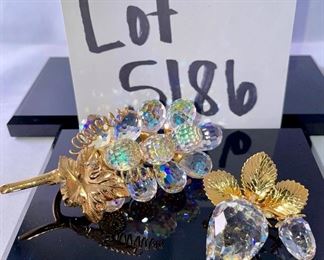 Lot 5186. $90.00. Crystal fun! Swarovski Crystal grape cluster, created as part of the "Sparkling Fruit" theme, faceted clear crystal grapes with gold plated leaves and a stem tip. Swarovski Crystal Strawberry Pin or Pendant with gold-tone leaves, An Unsigned mini elephant, crystal marble, and a trinket tray with a metal palm tree to round out the mix. 