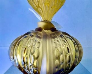 Lot 5190. $225.00. Lalique "Mirabel" Perfume Bottle, in frosted crystal Amber-ish glass. Signed. Brand new, was shrink-wrapped, but we wanted to make sure the markings on the outside matched, the item, so we opened the shrink wrap.  Stunning. Includes Box, outer sleeve, and all insert cards.  1 Mirabel Falcon 11208. Made in France	6"x4.75" roughly