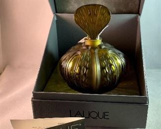 Lot 5190. $225.00. Lalique "Mirabel" Perfume Bottle, in frosted crystal Amber-ish glass. Signed. Brand new, was shrink-wrapped, but we wanted to make sure the markings on the outside matched, the item, so we opened the shrink wrap.  Stunning. Includes Box, outer sleeve, and all insert cards.  1 Mirabel Falcon 11208. Made in France	6"x4.75" roughly