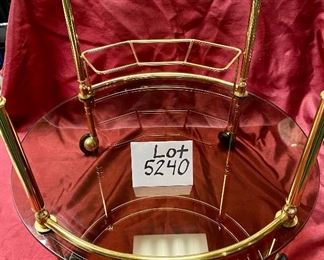 Lot 5240. $175.00 Vintage MCM Bar Cart on rubber castors. Brass and dark smoked glass, 2 tier with 3 bottle holders on the lower level. 27.5" H x 22"diameter. Handle to Handle: 23" W