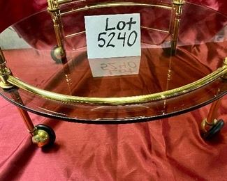 Lot 5240. $175.00 Vintage MCM Bar Cart on rubber castors. Brass and dark smoked glass, 2 tier with 3 bottle holders on the lower level. 27.5" H x 22"diameter. Handle to Handle: 23" W