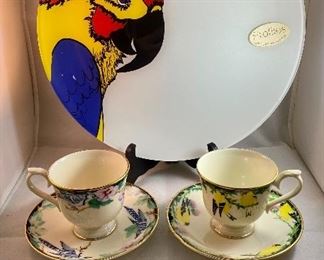 Lot 5152. $27.00  Lenox Birds of America Tea Cup and Saucers 1 Goldfinch and 1 Blue Jay (both issued 1993) and a Profiles Parrot Art Glass Plate 13" Diameter.