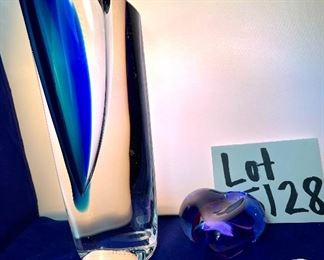 Lot 5128. $300.00. Kosta Boda Swedish Studio Art Glass pair, the first item is a Kosta Boda  by Gorän Warff Crystal Vase with contemporary beautiful lines and striking colors (11"t x 4"w) #49809, and a Kosta Boda heart beat art glass paperweight (3"x3"x1") by Bertil Vallien #90117 (both with boxes)